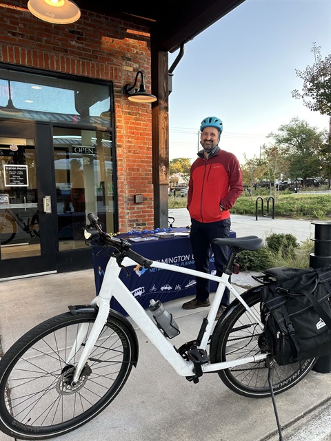 Man standing by his bike outside work