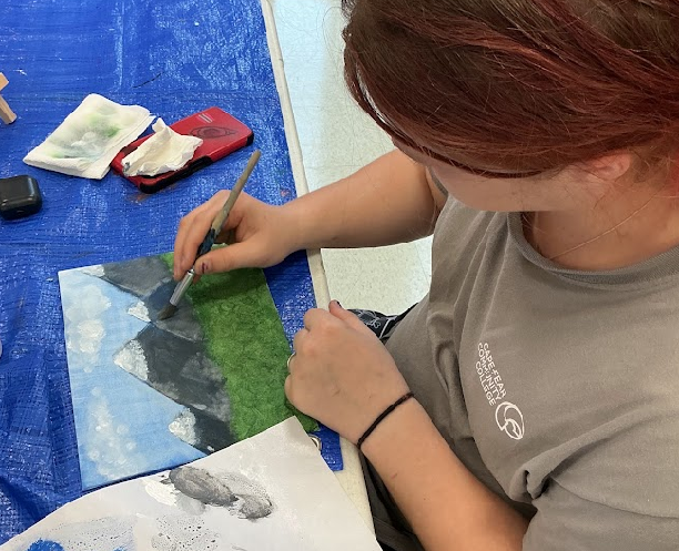 Girl painting picture on table.png