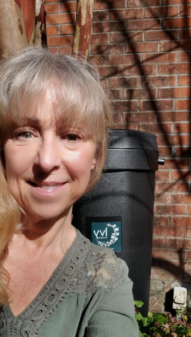 Person with an installed rain barrel