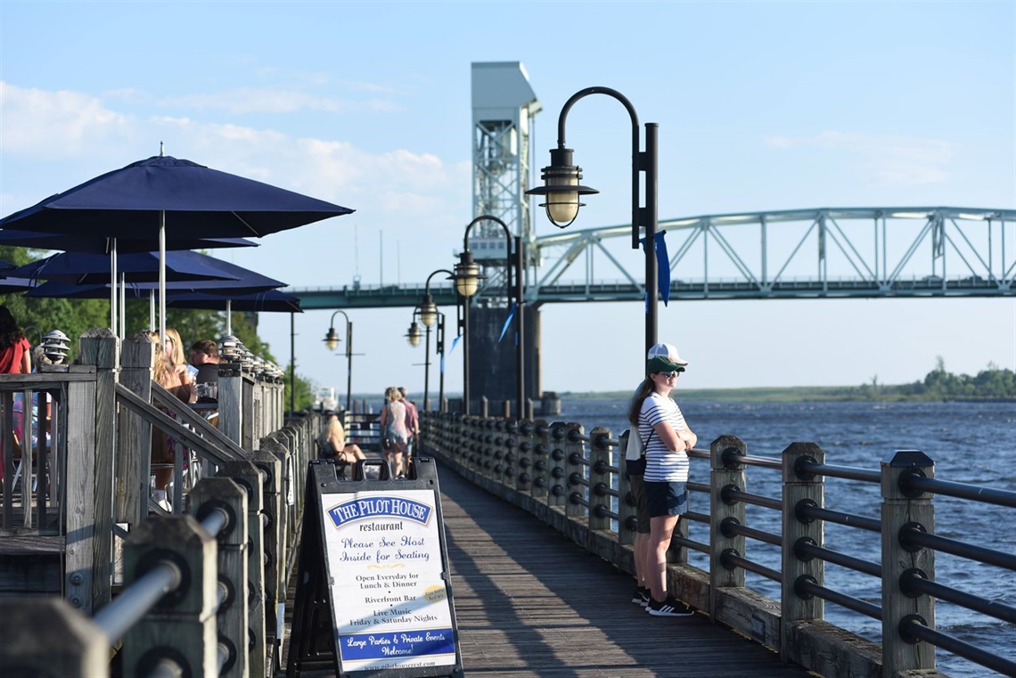Several people enjoying a nice summer day along the Riverwalk.